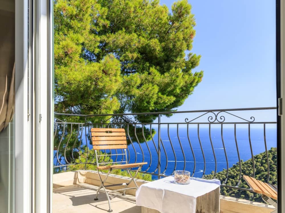 Terrace table at Apartment One with the sea framed by pines