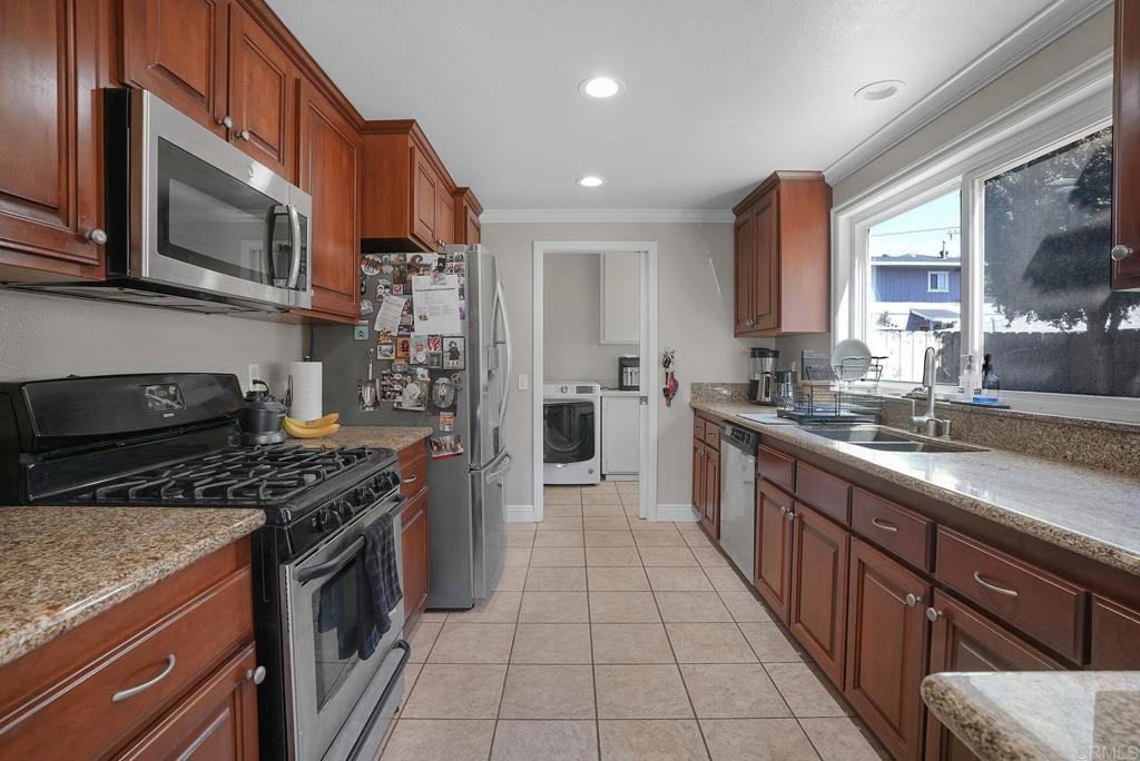 Functional kitchen with rich wood cabinetry, granite countertops, and stainless steel appliances.