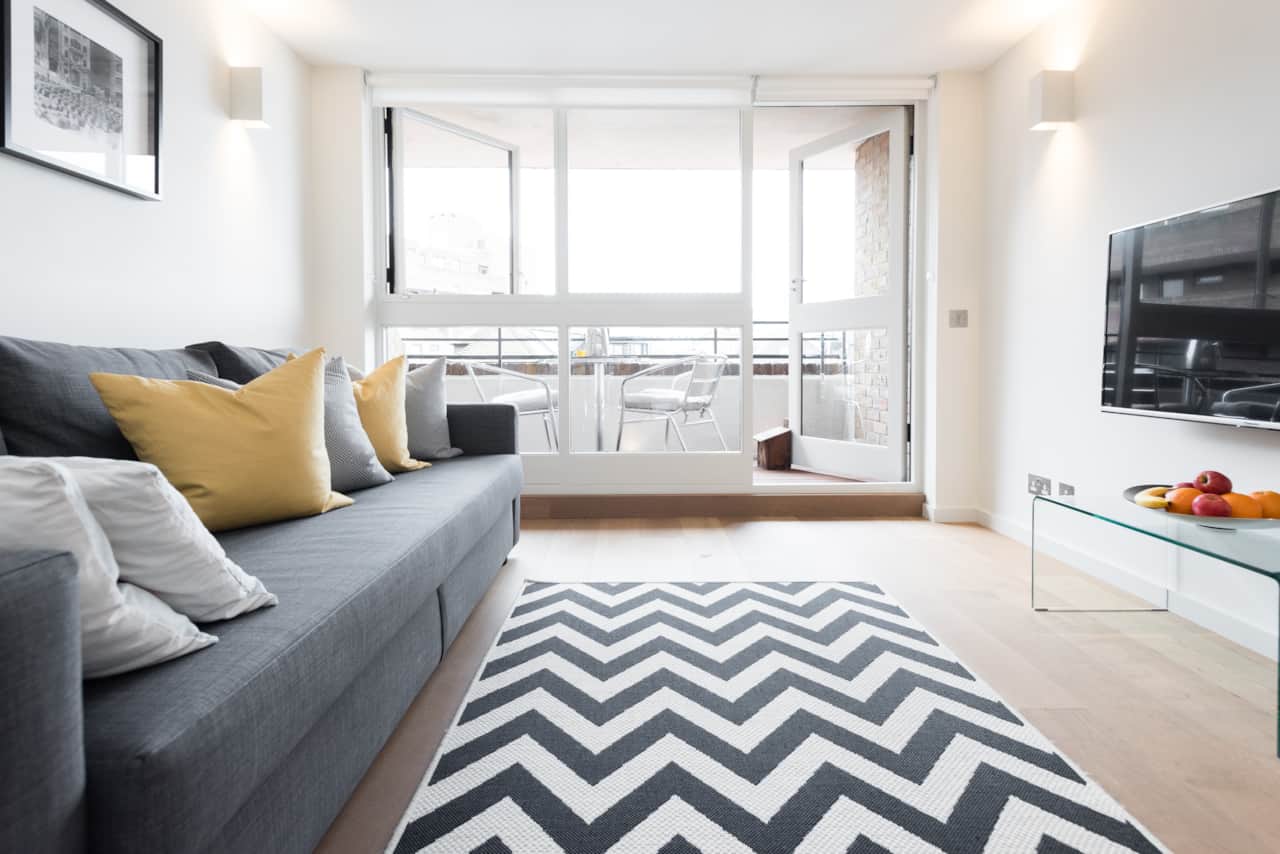 Chevron rug and grey sofa bed, opening onto a private balcony