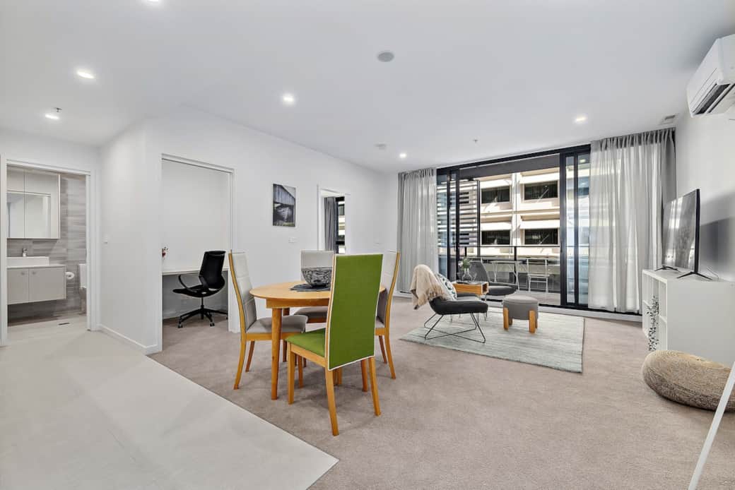 The dining area is thoughtfully designed to be both stylish and practical. The dining table is set in a well-lit space,  perfect for enjoying meals with a view of the living area. The windows in the living room flood the space with natural light.