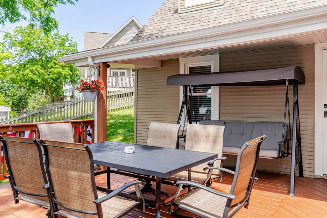 Dining area for six setup during summertime with a swing for seating three. Dining area for six setup during summertime with a swing for seating three.