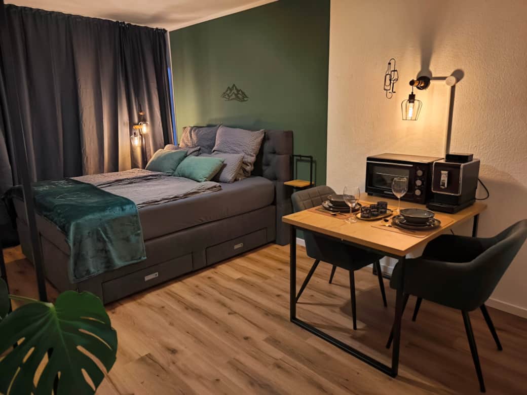 Dein Rückzugsort: Träume selig in unserem hochwertigen Queensize-Boxspringbett. Die stilvolle Akzentwand in Waldgrün holt die Natur des Harzes direkt in dein Schlafzimmer. Design trifft Gemütlichkeit.