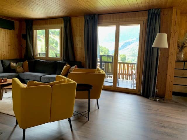 Vom Wohnzimmer gelangen Sie direkt auf den grossen Balkon mit Blick über das Tal und die Berge.
