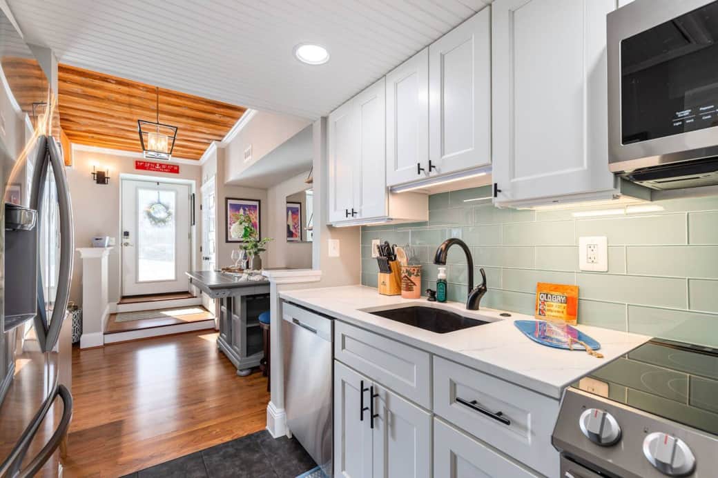 Kitchen with quartz countertops, dishwasher, oven, microwave, refrigerator with built in door water and ice