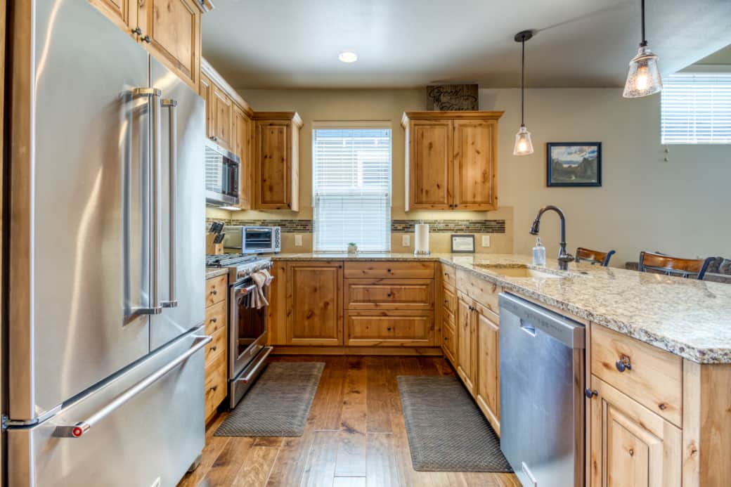 Full kitchen showing KitchenAid appliances, custom Alder cabinets, and hardwood floors