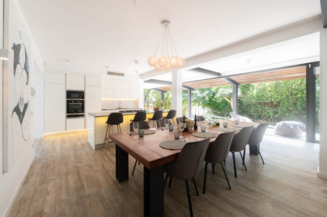 Open-plan living space with sliding doors to the garden at Casa Guindilla in Portals Nous, Mallorca