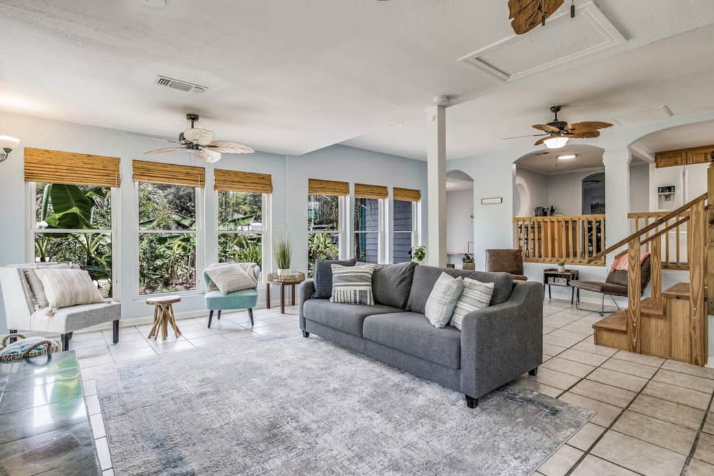 Enjoy natural sunlight and sweeping views of tropical plants in the living room while talking with friends and family. 