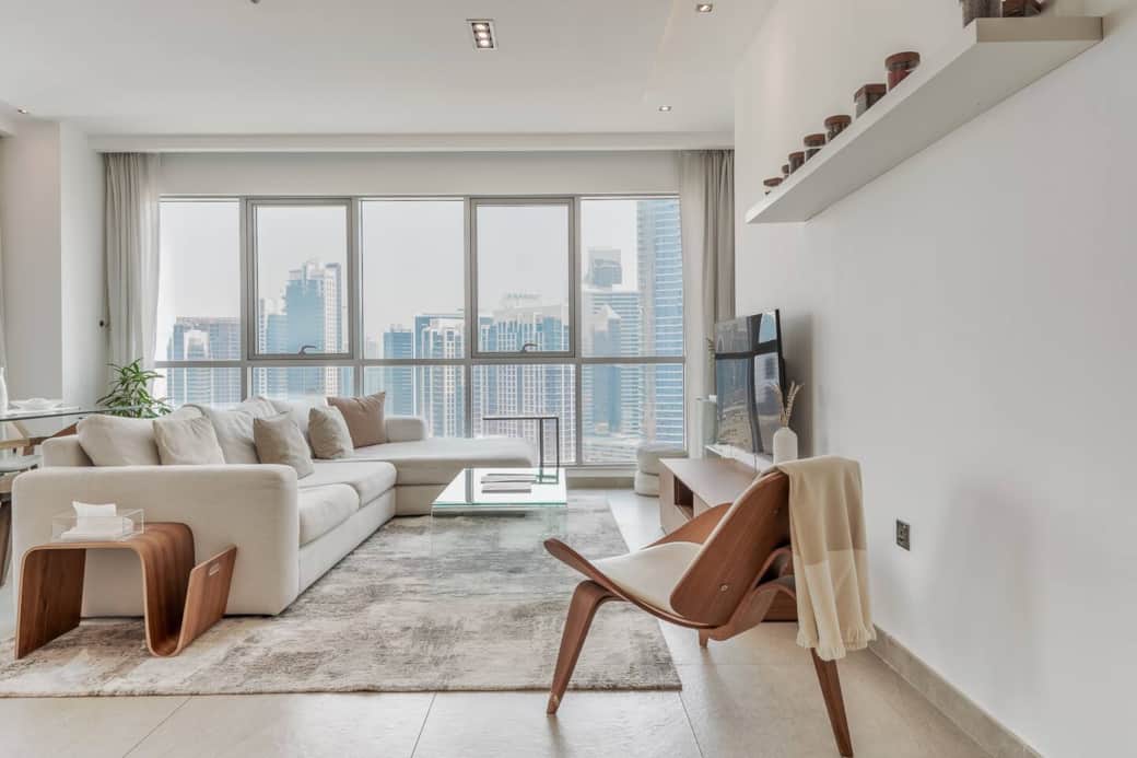 Spacious living room with modern furnishings, smart TV, and floor-to-ceiling windows perfect for relaxing or entertaining with stunning Downtown Dubai views.