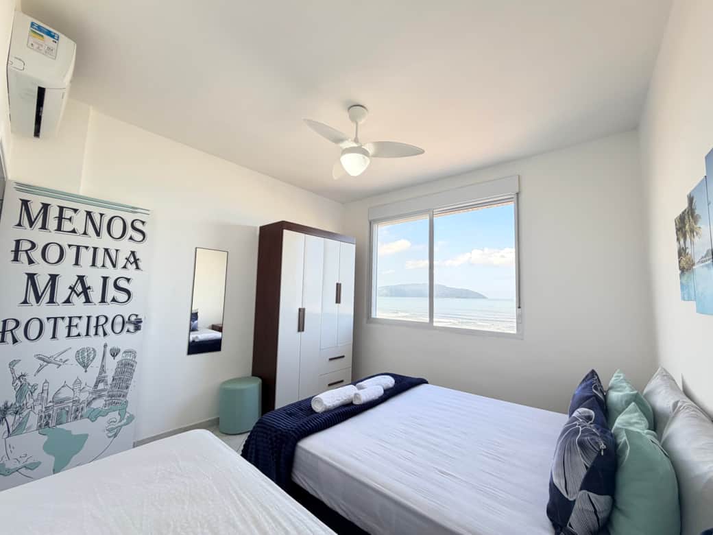 Quarto principal com vista para o mar em apartamento para aluguel por temporada.