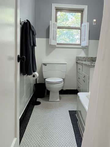 Bright bathroom with vanity, window light, and fresh towels.
