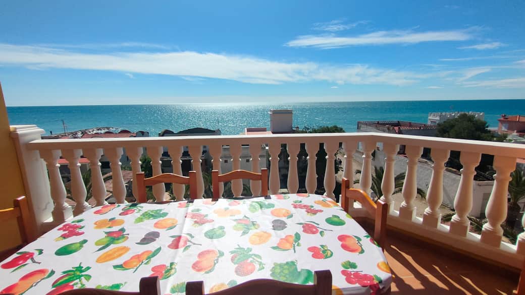 Balcón con mesa y vistas al mar