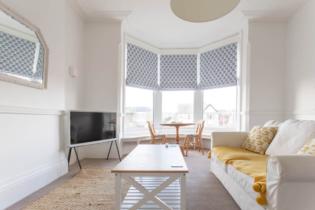 A spacious, bright living room. With huge bay windows, a dining area for two and a smart TV.
