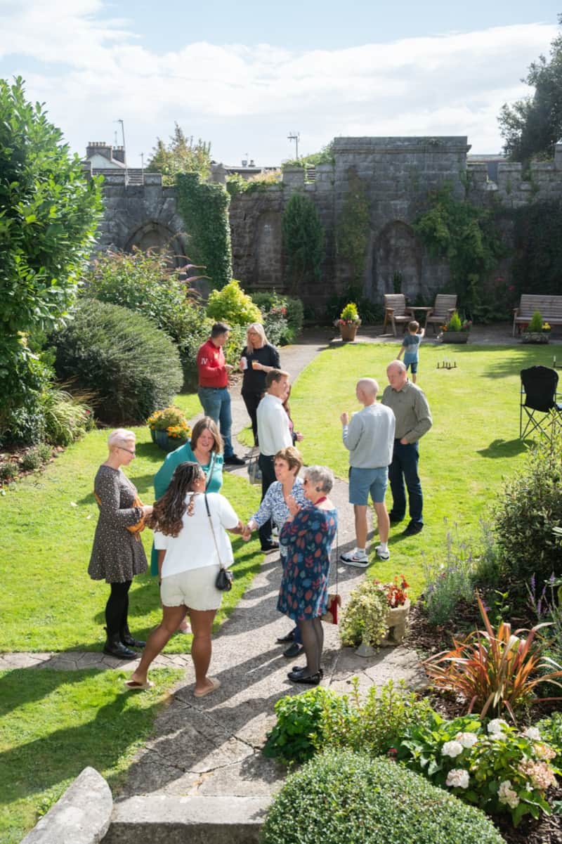 Guests mingling at a celebration in the walled Secret Garden