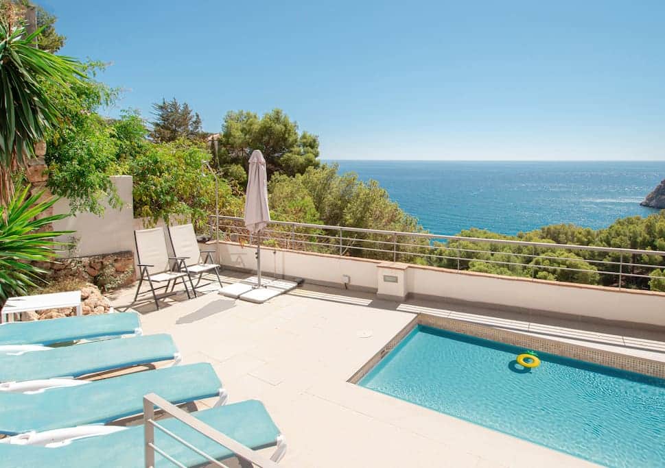 Sunny terrace with heated pool and sea view .