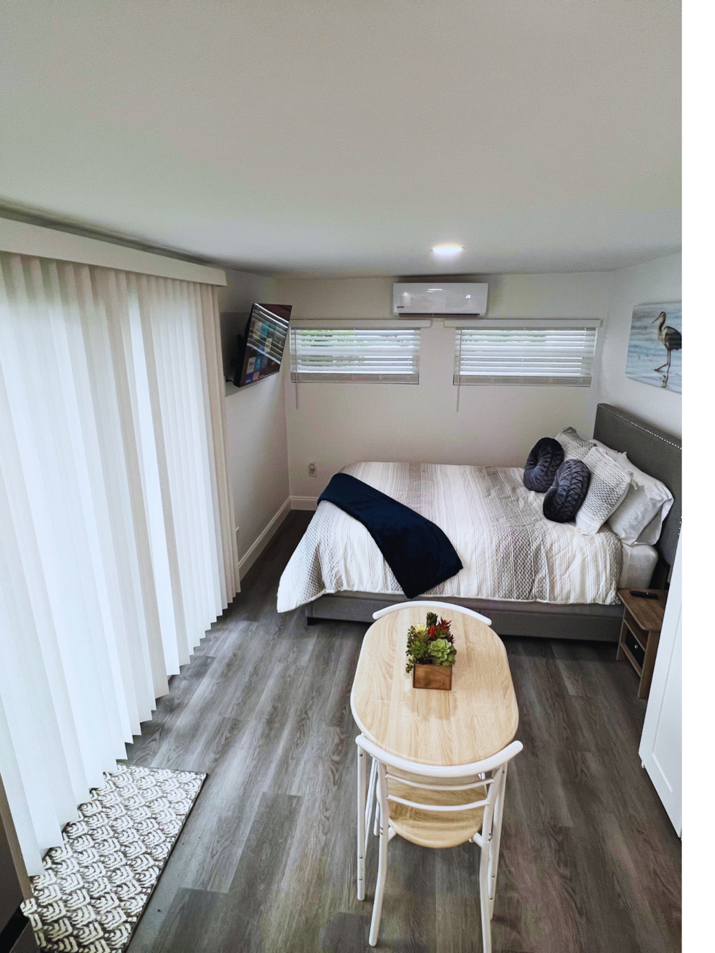 Room featuring AC, elegant blinds, and a bedside table. Lakeland, FL Room featuring AC, elegant blinds, and a bedside table. Lakeland, FL