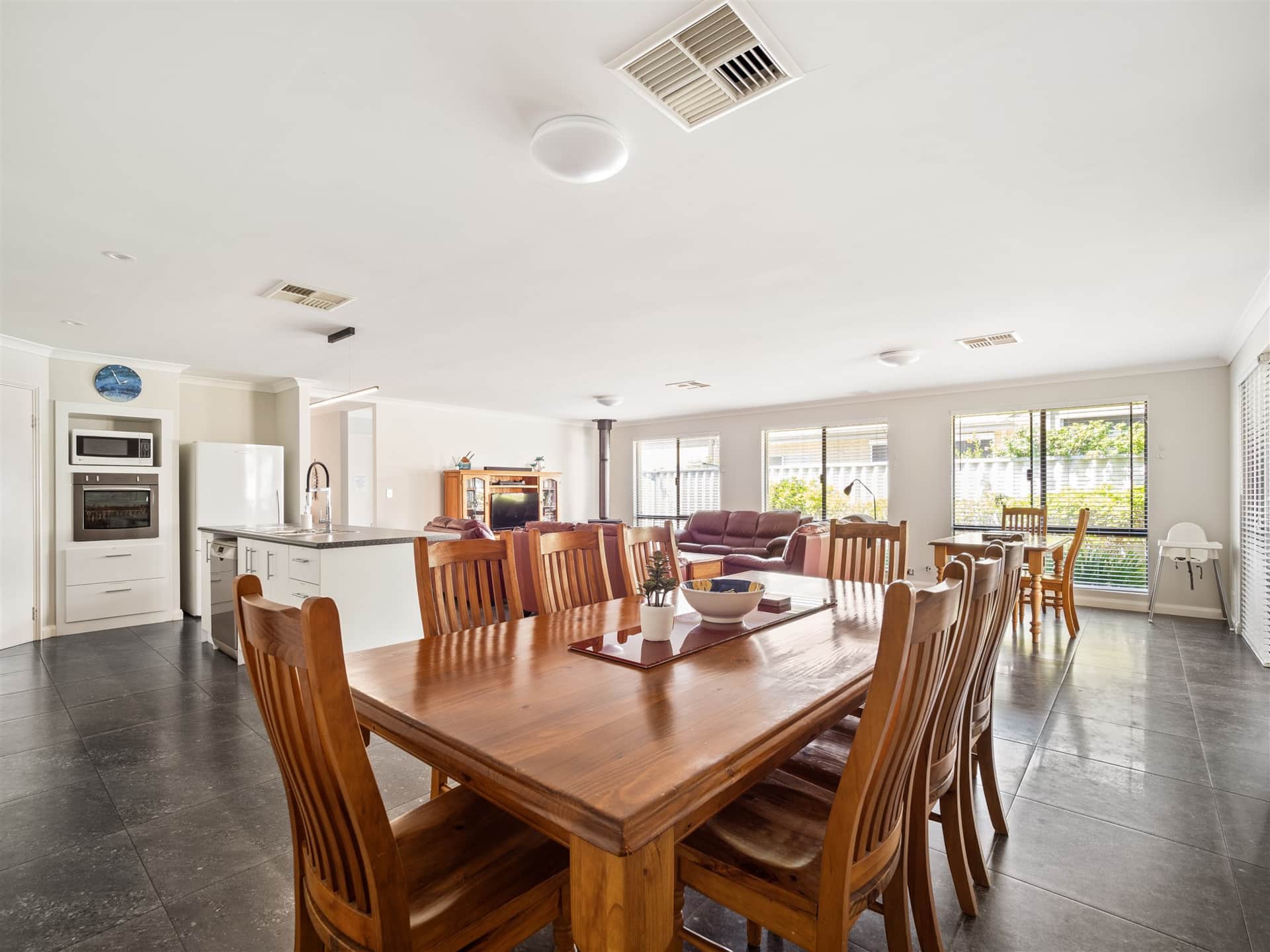 Large open plan family space with kitchen, two dining tables, lounge seating and a 60 inch TV