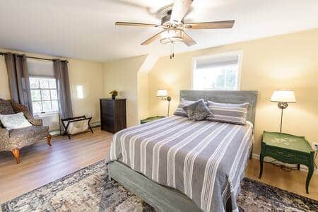 The large primary bedroom has a queen size bed, a large dresser and large walk-in closet