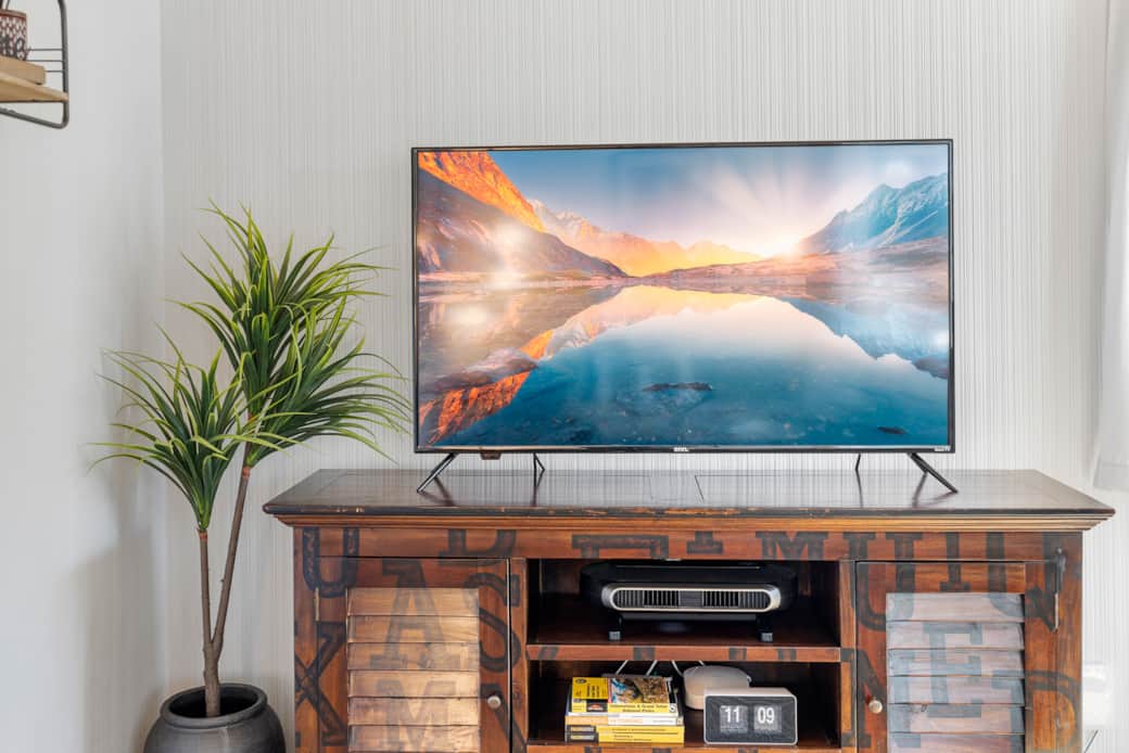 A modern lounge with a smart TV, cozy seating, and a touch of Wyoming charm.