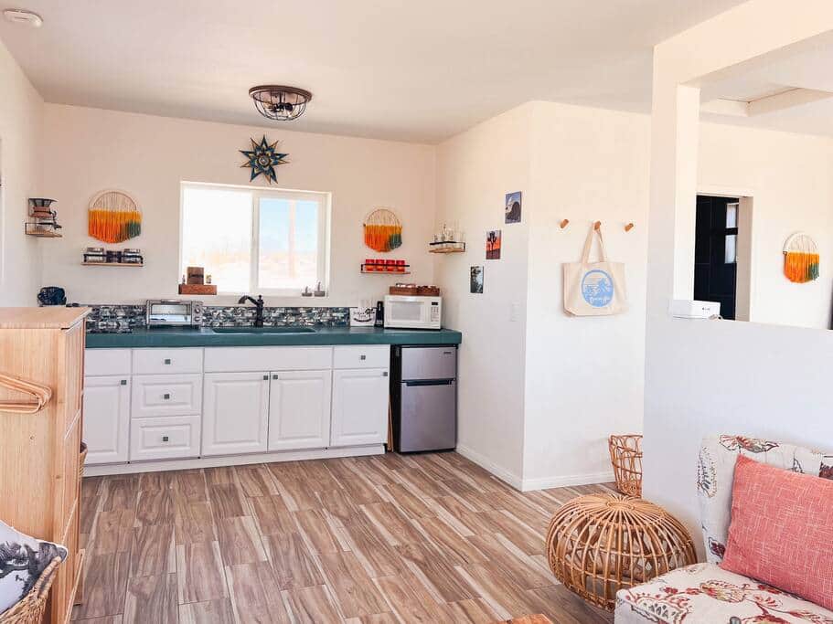 Kitchenette area with 2 burner stove, mini fridge, toaster oven, microwave and basic cooking items.