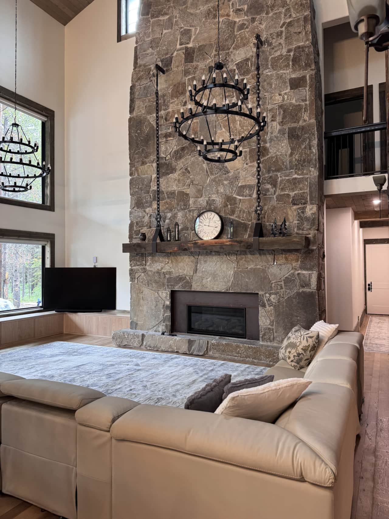 Soaring great room centered around a dramatic floor-to-ceiling stone fireplace