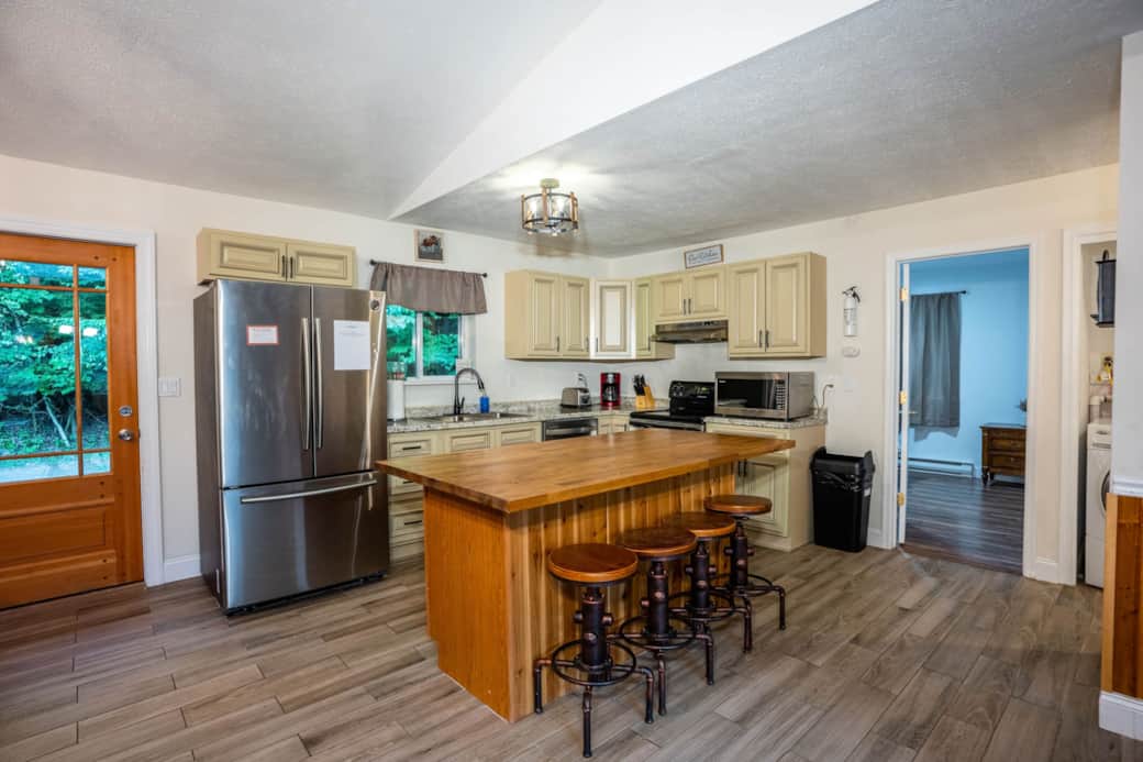 Open, inviting kitchen with custom-built butcher block, pots/pans, utensils