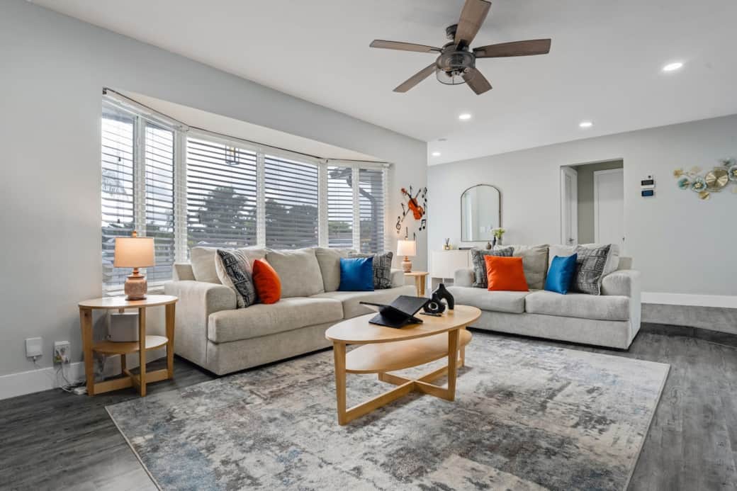 Airy, open living space with plush seating and abundant natural light. Perfect for relaxing or gathering, with stylish décor and board games stored in the TV stand for added fun and connection.