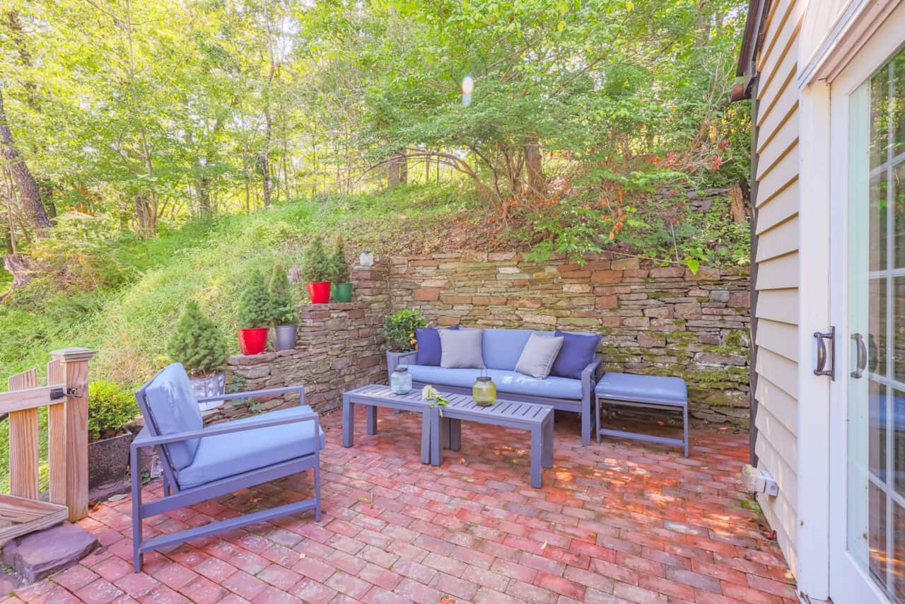 A private brick patio with blue seating and hand-stacked stone walls