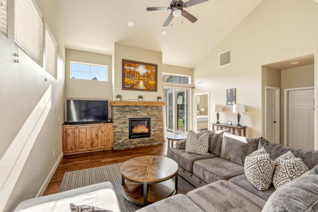 Great room with stone fireplace, slider open to private patio. Eagle Crest Retreat, Redmond OR.