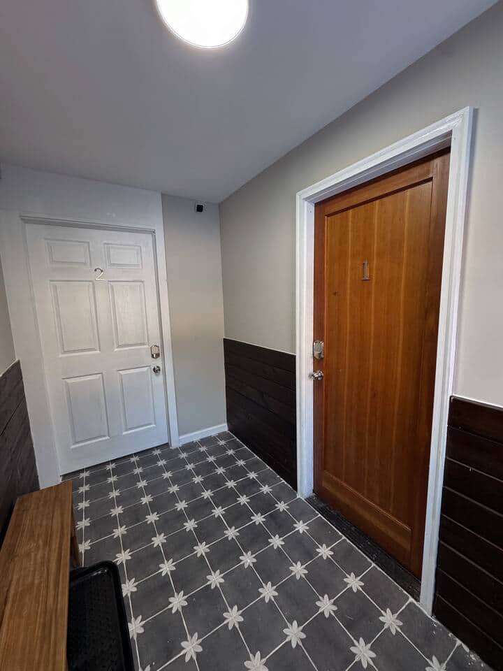 The Foyer, a common space of entry. The wooden door on the right, is the entry for the 1st floor apartment. This area has a ring camera for security and safety purposes. 