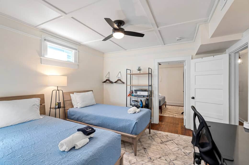 Bedroom # 2 two twin XL beds with adjoining door to bedroom #3 open which can be closed (see other picture).  Room darkening blind over the window. close hangers on the wall, large shelf with printer and random office supplies.