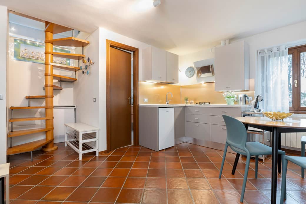 Overall view: bathroom door, kitchenette and dining area at a glance.