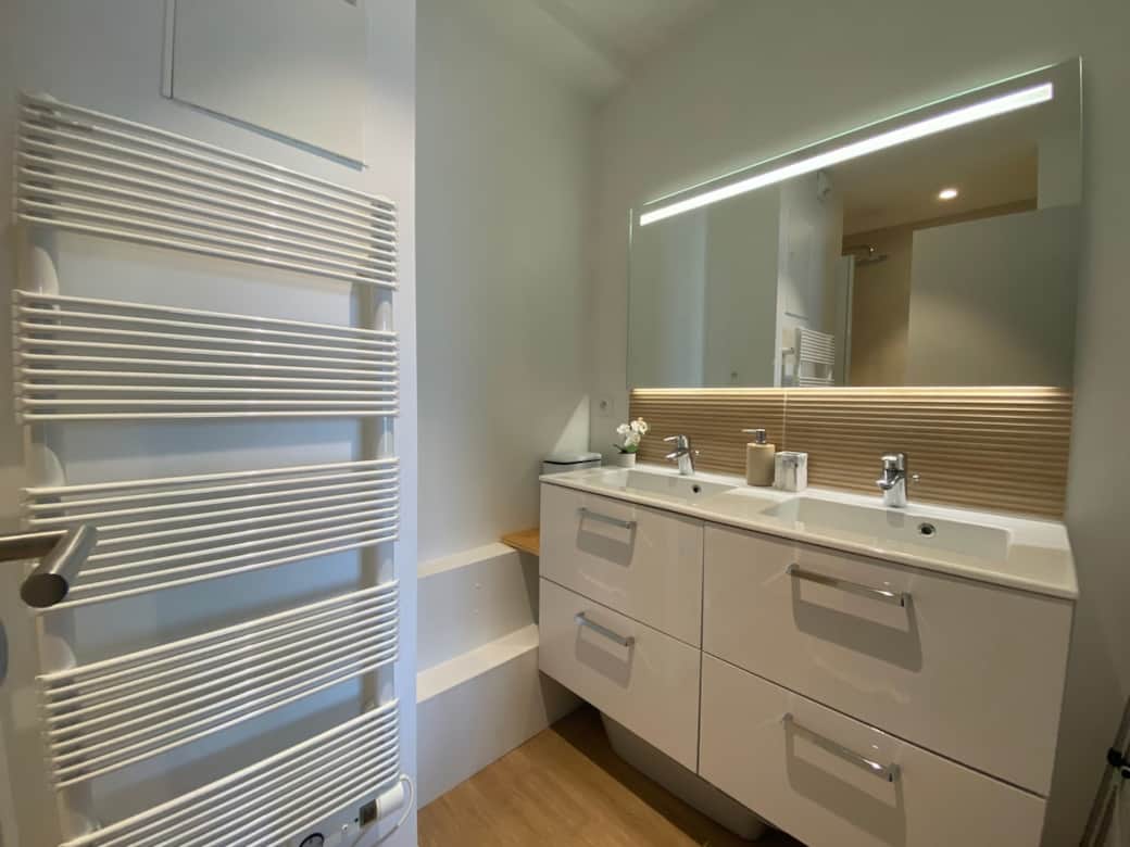 Salle de douche avec double vasque, sèche serviette et miroir anti-buée