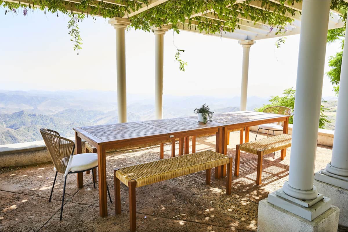 Long outdoor table under the pergola at The Ridge, with views over the hills