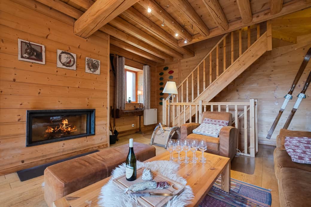 Warm living room with large fireplace, breathtaking view of the mountains and authentic decoration.