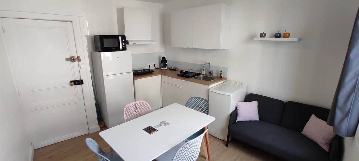 Espace de vie comprenant :
- une cuisine entièrement équipée
- une table à manger pour 4 personnes
- un espace salon avec canapé et TV