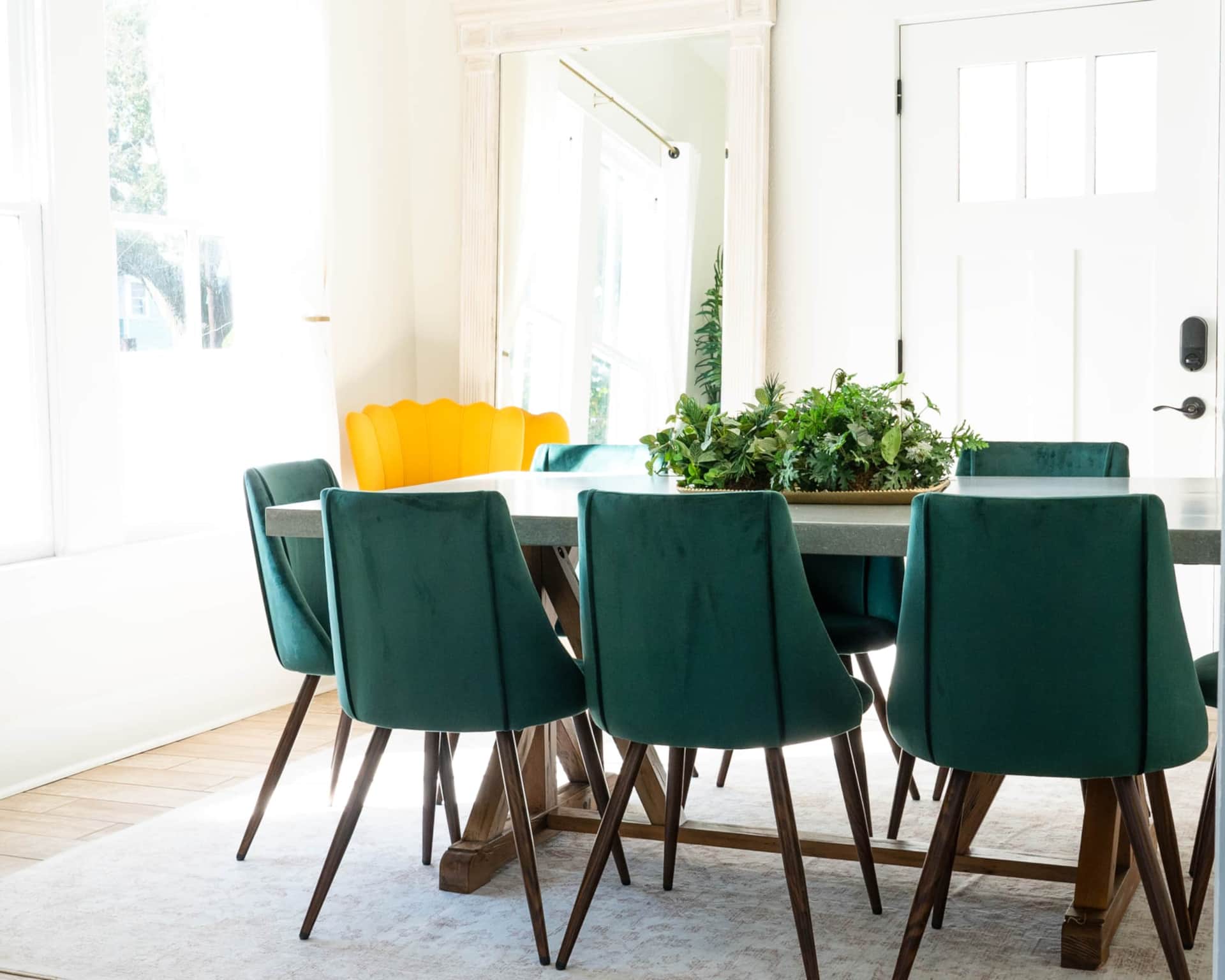 Elegant dining table seating ten guests and stately mirror at White Magnolia Galveston vacation rental.