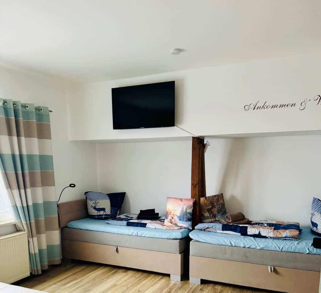 Schlafzimmer mit Doppelbett und zwei Einzelbetten