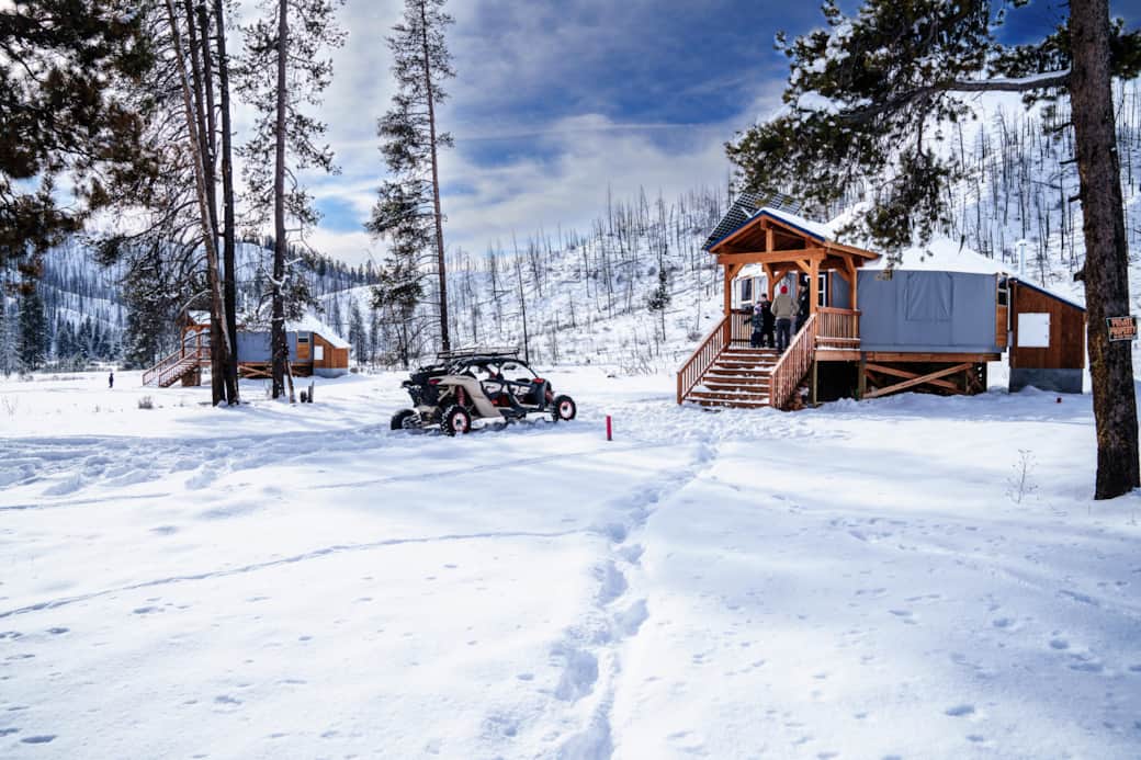 Blue and Green yurts blanketed in snow