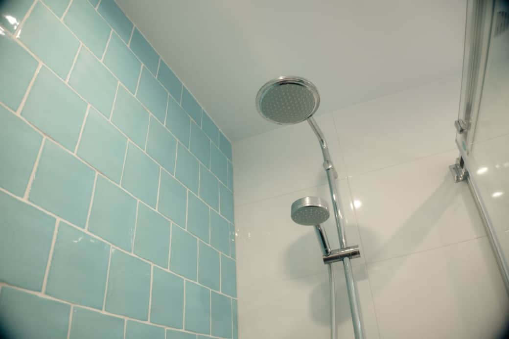 Step into the spacious walk-in shower, featuring a relaxing rain shower head and a flexible handheld wand.