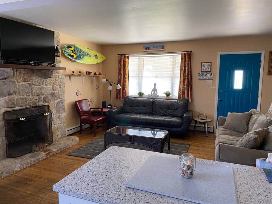 Living room with a large Roku TV, DVD player and two couches. (Fireplace is not functional)