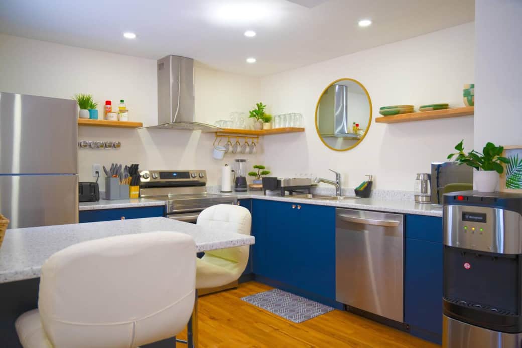 Fully equipped kitchen with everything you need to cook and dine in, including a stove, oven, fridge, microwave, dishwasher, water dispenser, pots, pans, and utensils. Perfect for enjoying home-cooked meals during your stay!