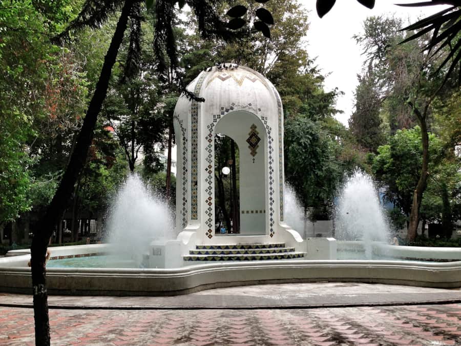 Tiled fountain and kiosk under the trees at Parque México, La Condesa
