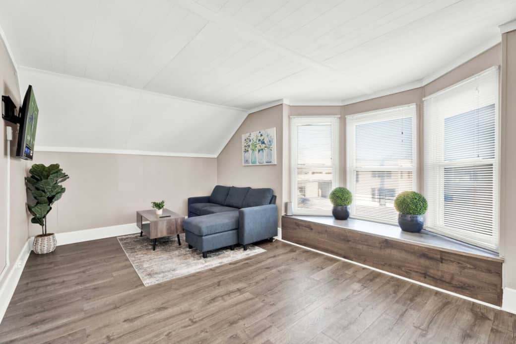 Couch, coffee table, large picture window, walk-in closet with hangers, dining table for 2, and big screen TV with remote and streaming apps available to sign in to.