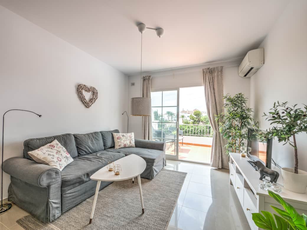 Bekvämt vardagsrum med AC och utgång till terrass.