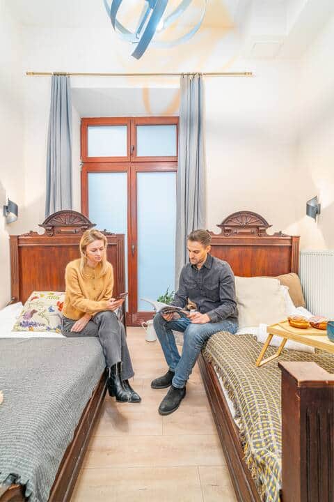 Przytulna sypialnia z dwoma łóżkami i jasnym, klasycznym wykończeniem.