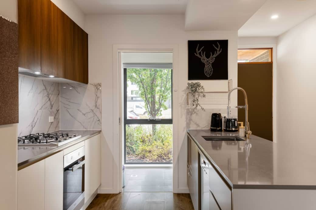 Step into a world of delicacies. Equipped with state-of-the-art stainless steel appliances, including a gas stove and a large refrigerator, this kitchen is a chef's dream. The ample counter space and modern sink make meal preparation a breeze. 