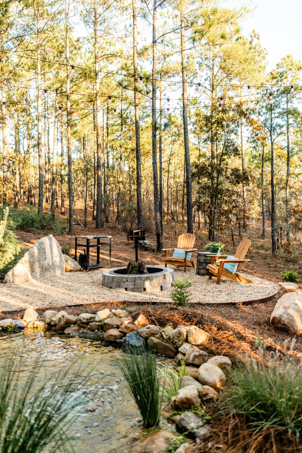 Firepit seating area with grill overlooking koi pond