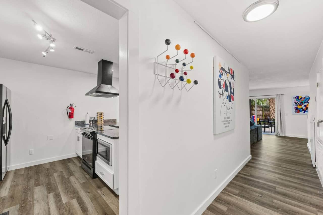 Step into Unit B, the left-hand home when facing the duplex. Its ground floor connects the kitchen, dining area, and smart-TV lounge, with a half bathroom and laundry for convenience. All three bedrooms and both full bathrooms are upstairs
