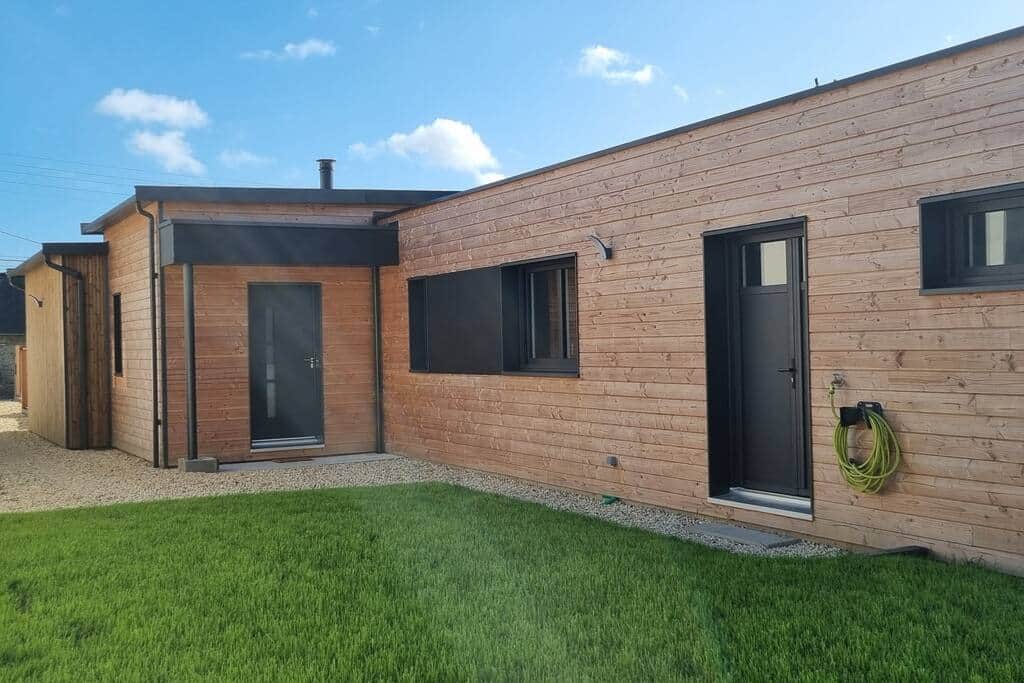 Côté entrée et parking de la maison avec partie engazonnée. Côté entrée et parking de la maison avec partie engazonnée.