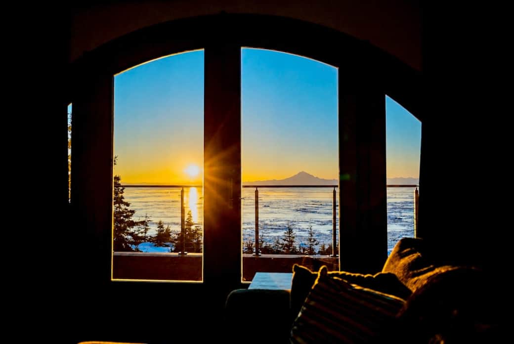 Oceanfront sunset view over Cook Inlet and volcano range